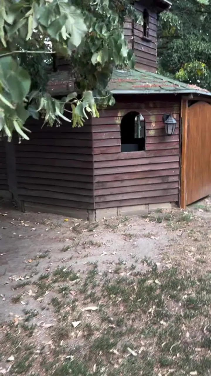 Drvena kućica od tamnih dasaka na igralištu